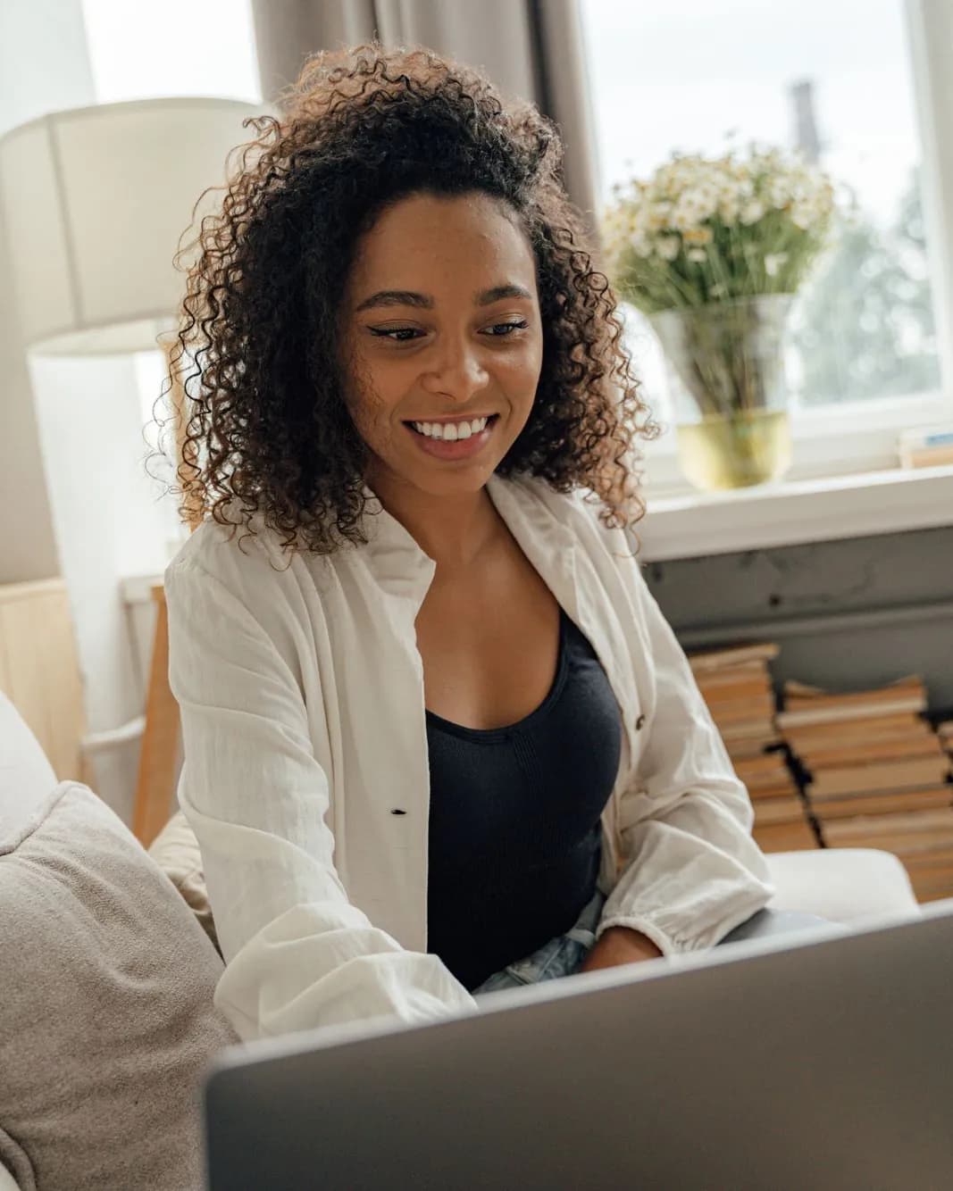 Smiling woman on a video call from her laptop in a bright living room